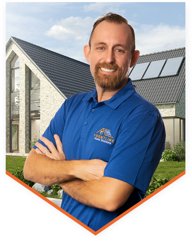 A man in a blue polo shirt with Frontline Home Solutions logo and standing in front of a house with arms crossed and smiling