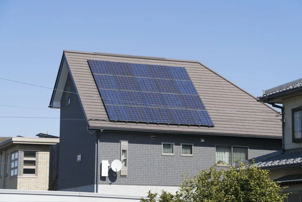 The side of a brick house with a solar panel on the roof
