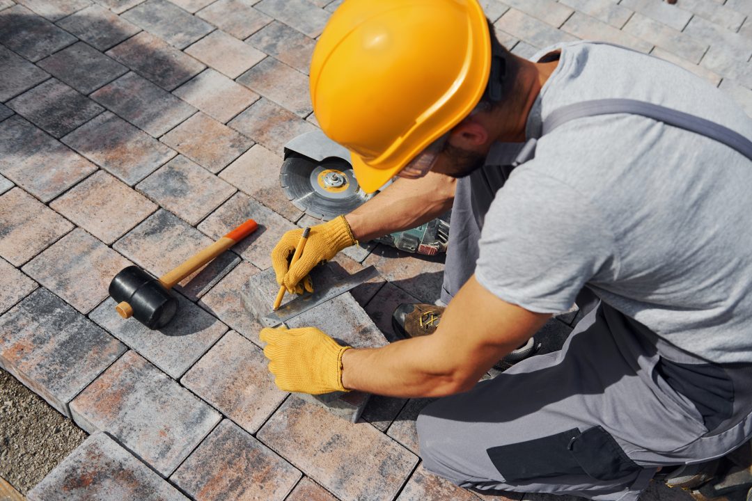 Male worker in yellow colored uniform have job with pavement.