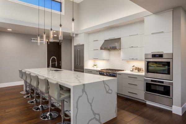 Beautiful Modern Kitchen In New Luxury Home. Features Large Waterfall Island with Double Ovens and Hardwood Floors