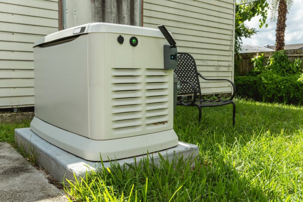 A Home Standby Generator installed at the backyard of a house. An air-cooled natural gas or liquid propane generator for residential use.