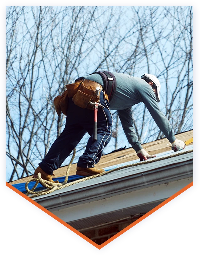 a man working on the roof of a house