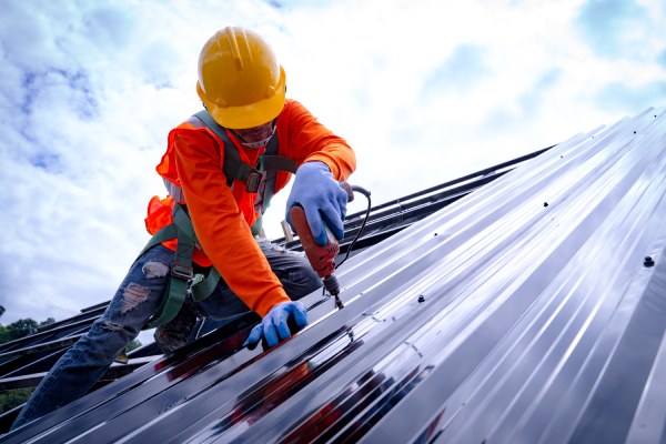 Techador trabajando en la estructura del tejado de un edificio en construcción