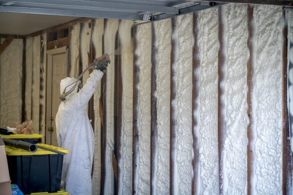 Trabajador rociando espuma aislante en spray de célula cerrada en una vivienda inundada por el huracán Harvey.