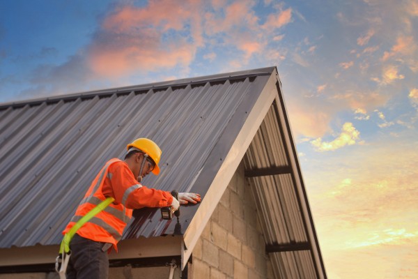 Obrero de la construcción instalador de tejados nuevos,Herramientas para tejados,Taladro eléctrico utilizado en tejados nuevos con chapa metálica