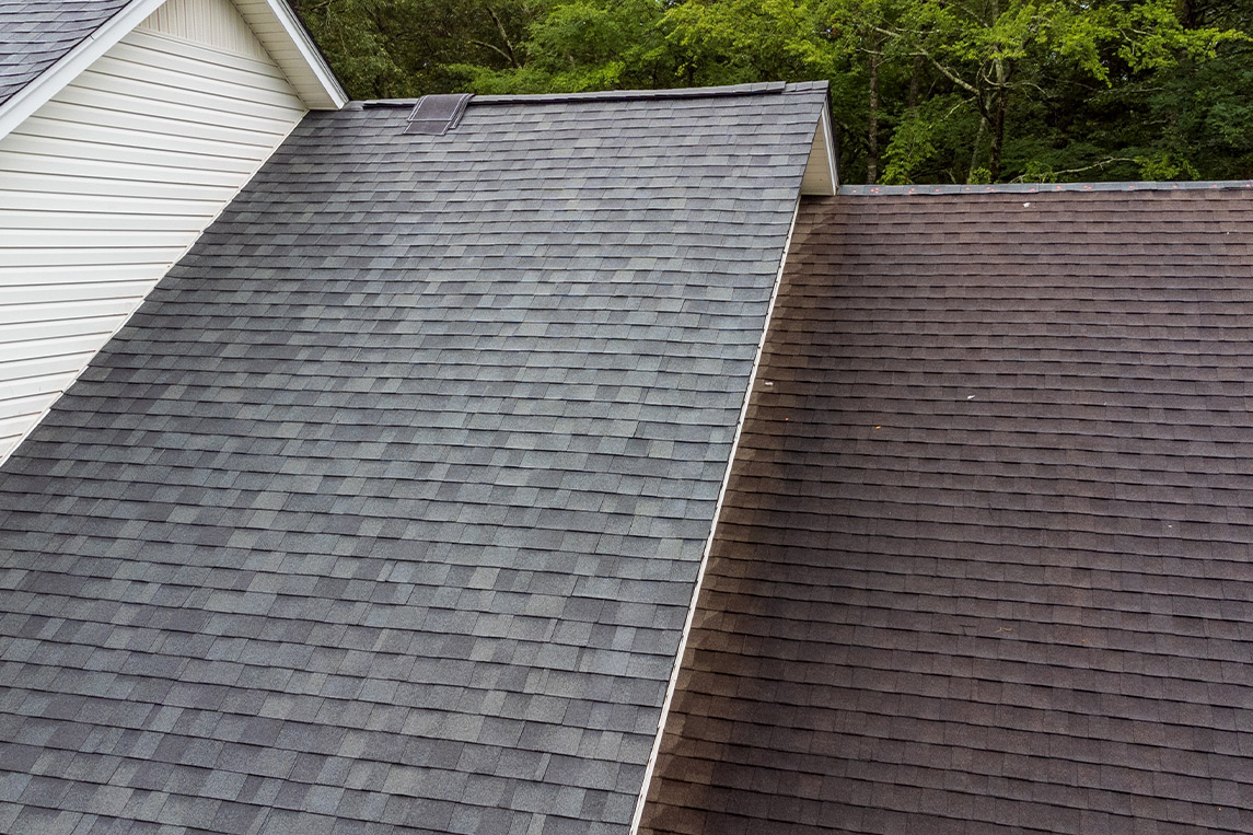 Gray roof - Repair and Replace the House Roof with Handyman with Tools and Pprotective equipment. Stand on the Roof with the Ssky Background.